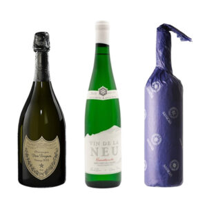 Dom Pérignon, Vin de la Neu and Sassicaia bottles side by side. Showcasing a luxury wine trio.