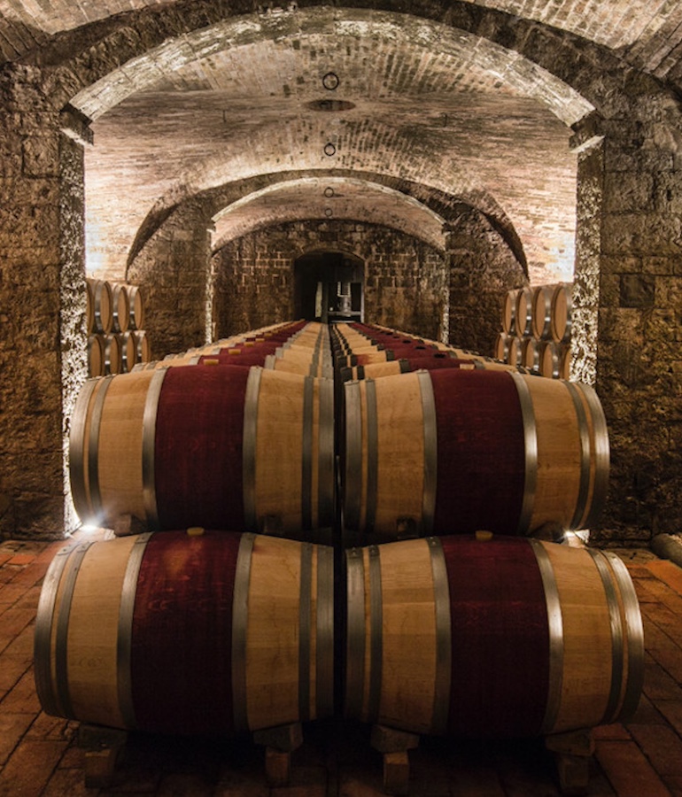 Wine barrels in a world-renowned Tuscan winery, symbolising Italian winemaking excellence.