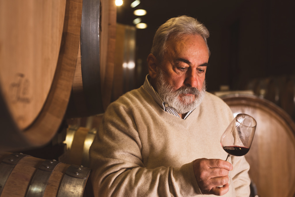 Founder of Vinchio Vaglio holding a glass of red wine, symbolising tradition and excellence.