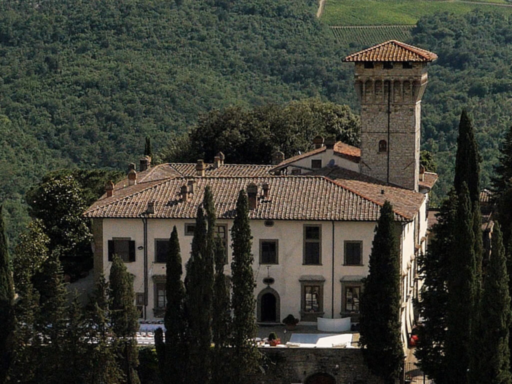 A scenic view of Castello Vicchiomaggio surrounded by rolling vineyards in the heart of Chianti Classico.